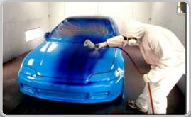 Auto Body painter in paint booth painting car